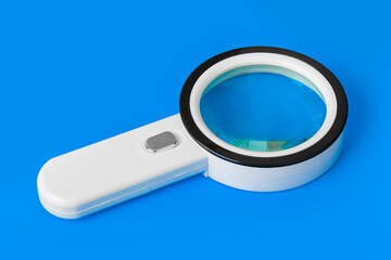 Magnifying glass on blue