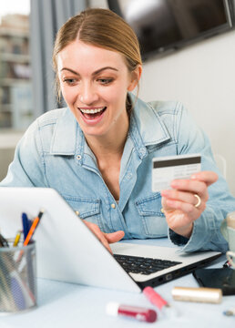 Girl buying online with laptop and credit card at home. High quality photo