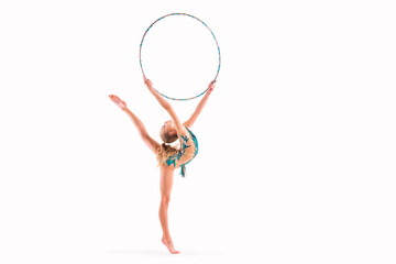 A gymnast girl in an emerald swimsuit performs an exercise with a hoop isolated on a white...
