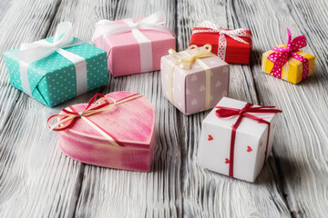 Various gift boxes on old light wooden background. Valentine’s day background