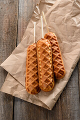 Top view on waffle corndogs on wooden background