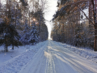 Droga przez las zimą, zaśnieżone drzewa