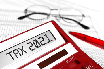 Word Tax 2021 on calculator. Business and tax concept on white background. Top view.