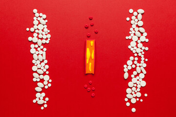 Treatment of atherosclerosis. Model organ lying on a red background with pills.