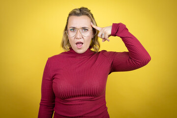 Young caucasian woman wearing casual red t-shirt over yellow background smiling and thinking with...