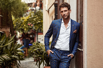 Young handsome man in classic suit with checked pattern