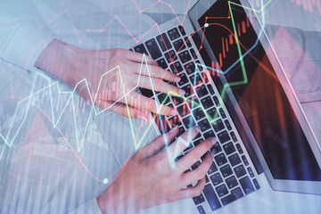 Double exposure of woman hands working on computer and forex chart hologram drawing. Top View. Financial analysis concept.