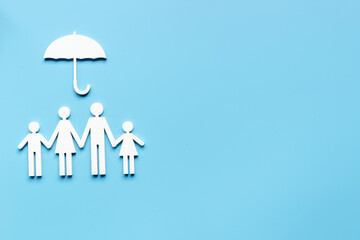 Wooden family figure under umbrella with space for text. Insurance concept