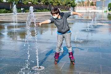 Caucasian boy with a mask and skates, skating on the water in the park fountain.