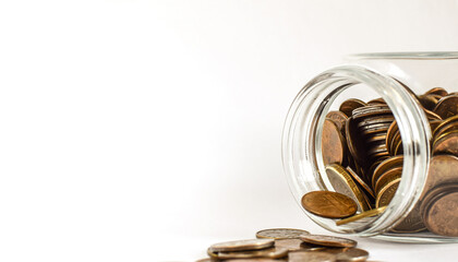 The glass jar fell and the metal coins fell apart. Image of metallic money on a light background. Store and protect savings. Copy space. Selective focus.