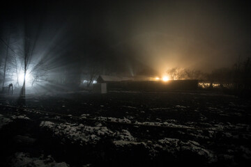 Obraz premium Mountain Road through the snowy forest on a full moon night. Scenic night winter landscape of dark blue sky with moon and stars
