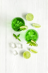 Glasses of iced mojito or lemonade with lime and mint