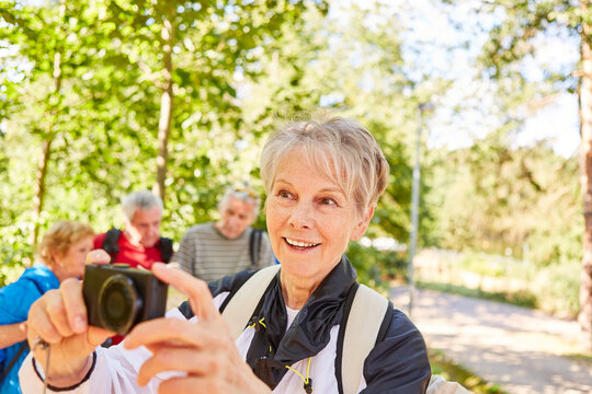 Senior woman takes photos of the hiking group