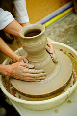 working with clay on potter's wheel