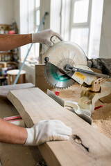 Carpenter working on wood with electric jigsaw in workshop. Joinery work on the production of wooden furniture. Small Business Concept
