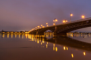 Fototapeta na wymiar Beleuchtete Brücke über den Rhein bei Mainz an einem Winterabend mit Hochwasser