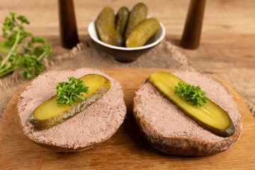 Liver pate cut on a bun with parsley and cucumber