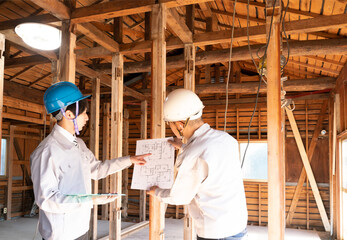 住宅建築現場で働く人々　スケルトンリフォーム　打ち合わせ