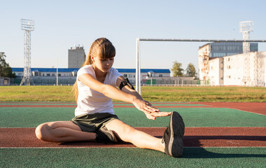 Teenager girl doing stretching at the stadium