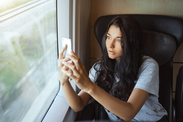 Fototapeta na wymiar Tourist Woman Traveling in the Train with Smartphone.