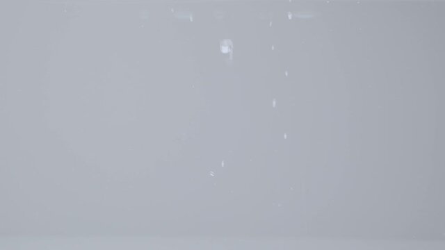 Ice cubes falling into water in slow motion
