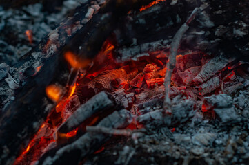 Small flame dying fire, bright red-orange flame. Cozy warm atmosphere by outdoors campfire...