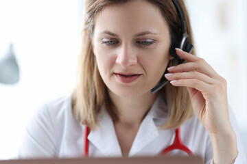 Female doctor in headphones speaking into microphone