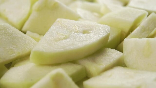Slice of fresh ripe sliced peeled zucchini drops with rotation close up macro shot