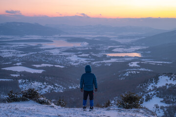 Alpinist watching sunset from Becku mountain in Baydari valley 