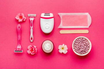 Cosmetics set for epilation with epilator and wax strips and flowers. Top view