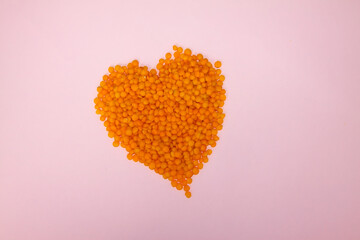 Closeup of red lentils. Heart from food. Heart of red lentils. Ingerdience for cooking.