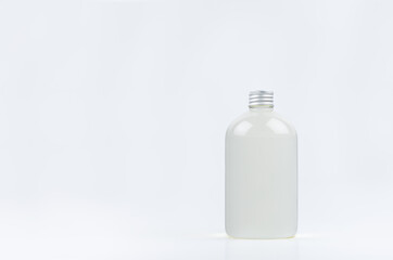 Transparent plastic low thick bottle with water or cosmetic product with silver cap mockup on white background, template, copy space.