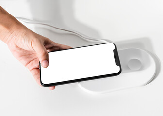 Hand connecting smartphone to wireless charger