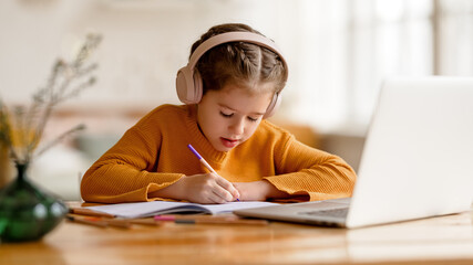 Focused girl making notes during remote education