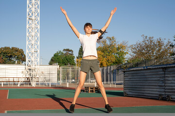 Fototapeta na wymiar Teenager girl working out at the stadium doing jumping jacks