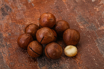 Brown macadamia nut heap over background