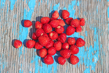 a handful of strawberries on an old wooden background