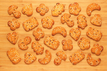 curly cookies with sesame seeds on a wooden background