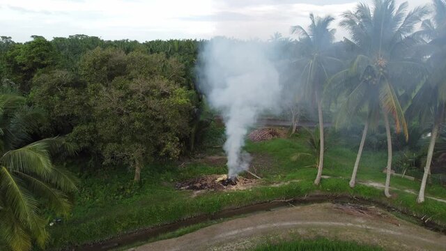Aerial ascending look down open fire burning in farm