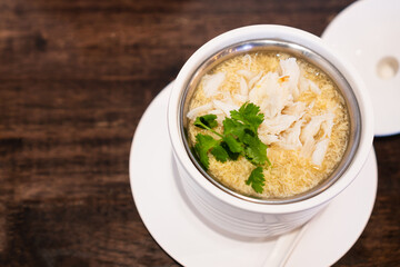 Asian crab egg soup on wooden table in restaurant. Chinese food concept. Top view