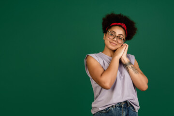 Pretty cute. African-american beautiful woman's portrait isolated on green studio background with copyspace. Female model with eyewear. Concept of human emotions, facial expression, sales, ad, fashion
