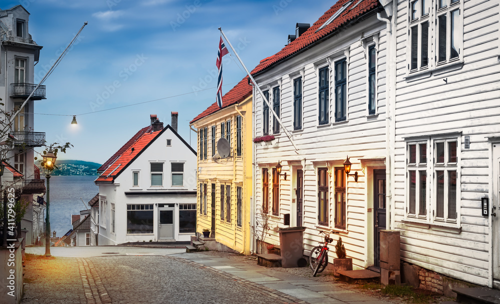 Poster Bergen, Norway old narrow street with wooden houses at twilight.