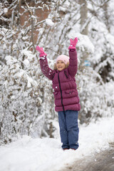 A child girl on a walk in a winter park