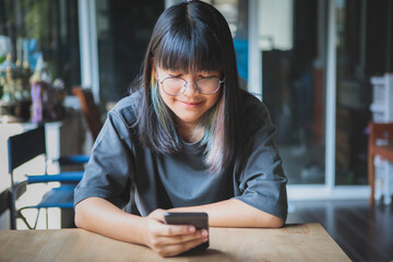 asian teenager reading message on smart phone in hand