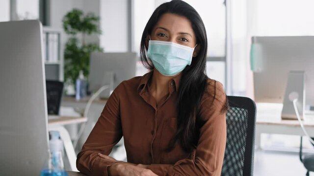 Video portrait of woman in protective mask in the office. Shot with RED helium camera in 8K.