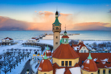 Obraz premium Beautiful sunset over the snowy beach and pier (Molo) in Sopot at winter. Poland