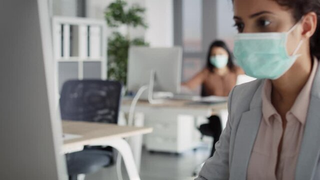 Video of women in protective face mask working in office. Shot with RED helium camera in 8K.