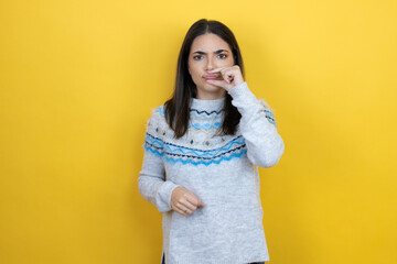 Young caucasian woman wearing casual sweater over yellow background mouth and lips shut as zip with...