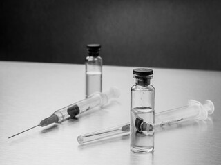 Syringes and ampoules on a polished metal background. Coronavirus vaccination and immunization...