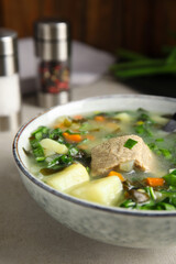 Delicious sorrel soup with meat served on table, closeup